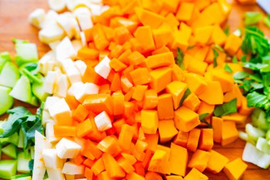 Mutfak tahtasındaki doğranmış ve hazırlanmış sebzeler pişirilmeye ve çorbaya dönüştürülmeye hazır..