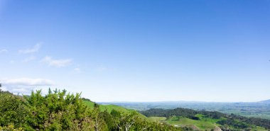 Hawkes Körfezi, Yeni Zelanda boyunca açık mavi gökyüzü altında panoramik manzara.