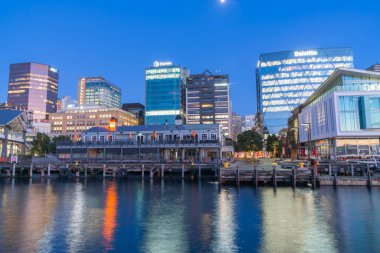 Wellington Yeni Zelanda _ 27 Temmuz 2021; Geçmekte olan araç ve ışık akımları Jervois Quay kavşağındaki kentsel gece arkaplanı için bulanık