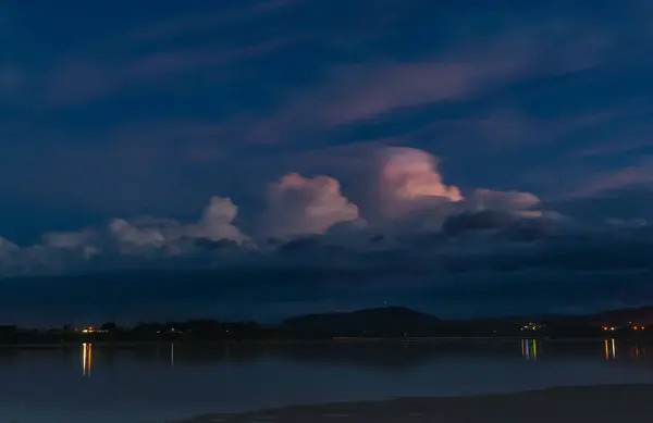 ニュージーランドの白い雲と輝くピンクのパフを打つ光と暗い不吉な空 — ストック写真