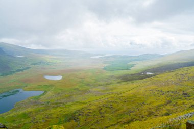 Küçük gölleri ve kurumuş taş duvarları olan vadi alanları Connor Geçidi 'nden geçerek Dingle Yarımadası, İrlanda.