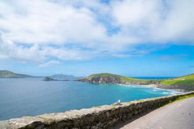 Körfez, yol ve kaya duvarlarıyla çevrili ve düz yeşil alanlar boyunca uzanan dik, dramatik kayalık uçurumlarla dolu. İrlanda 'da.
