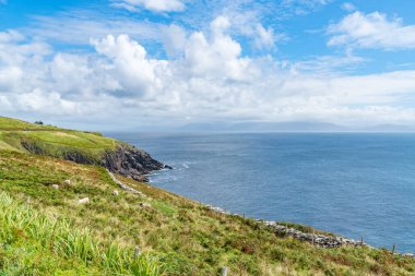 Vahşi Atlantik Yolu boyunca uzanan düz yeşil arazili sarp kayalıklar..