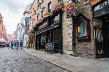 Dublin, IRELAND - 10 AĞUSTOS 2017; Tapınak Bar bölge sokakları ve popüler miras bölgesindeki yerel halk ve turistlerin bulunduğu binalar ve Quays Bar 'ın ön cephesi .