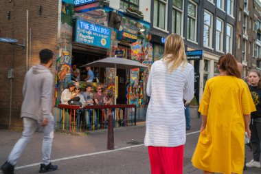 Amsterdam, Hollanda - 17 Ağustos 2017; Şehrin genelev mahallesindeki Bulldog Kafe 'nin önünden geçen insanlar.