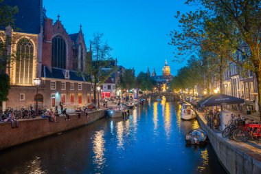 Amsterdam Hollanda - 17 Ağustos 2017 Kanal kenarlarında gece hayatı geleneksel Hollanda tarzı binalar tarafından her iki tarafta da katedrale doğru sıralanmıştı...