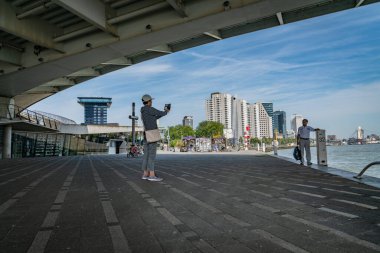 Rotterdam Hollanda - 23 Ağustos 2017; Siluet kemer yapısı ile çerçevelenmiş şehir siluet köprü altında fotoğraf çeken turist