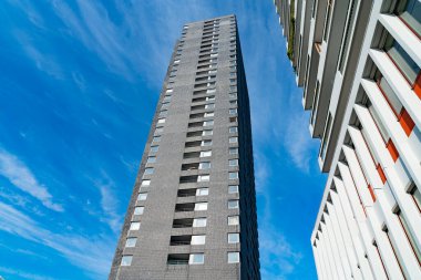 Rotterdam Hollanda - 22 Ağustos 2021; Gökyüzüne doğru yükselen Brutalist tarzı beton ve cam Stark yüksek katlı apartman blokları şehrin kentsel manzarasının üzerinde yükseliyor.