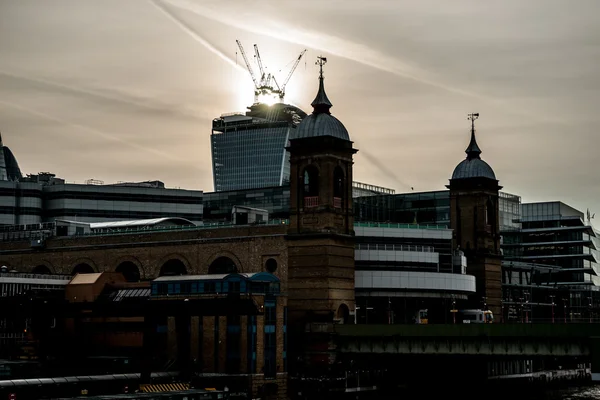 Kräne auf dem neuen Gebäude hinter Silhouette traditionellen Stil Stadtarchitektur — Stockfoto