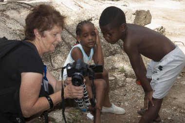 Turist yerel çocuk fotoğrafları Havana fotoğraf makinesinde gösterir