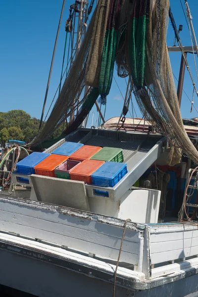 Ağlar ve renkli saklama kutuları asılı ile balıkçı teknesi — Stok fotoğraf