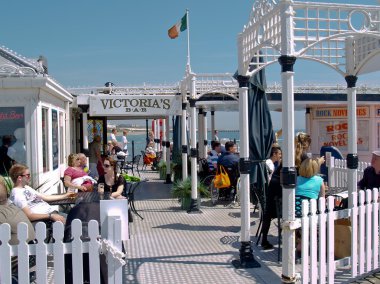 Victoria'nın işareti ve müşterilerin Brighton Pier üzerine kalabalık Bar