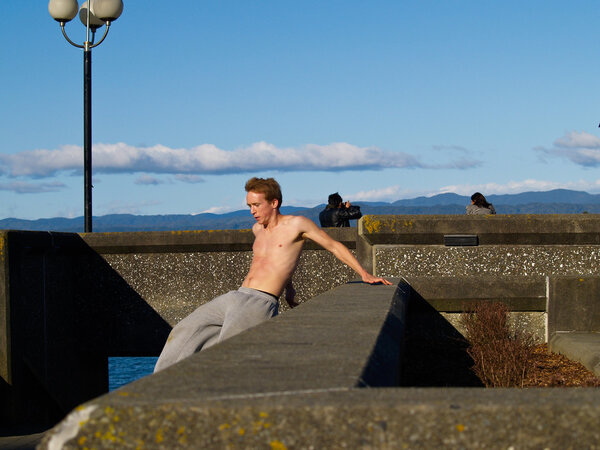 bare chested young man practicing building jumping or parkour