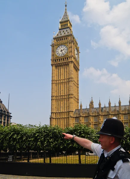 Londoner Polizist weist mit großem Ben im Hintergrund den Weg. — Stockfoto