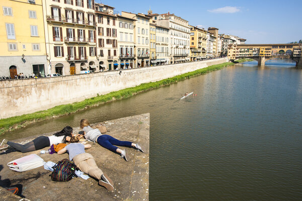 Students enjoying sunny day on bridge pontoon in Florence.