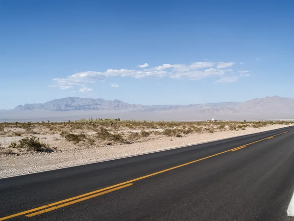 Garis kuning di jalan yang menegang melalui gurun Nevada — Stok Foto