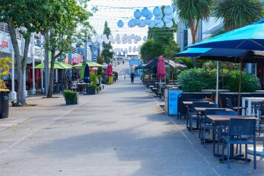 Tauranga Yeni Zelanda 30 Eylül 2025; Mobilyaları, ağaçları ve merkezden geçen patikaları olan Kafeler ve barlar.