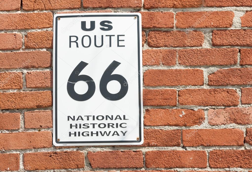 US Route 66 National Historic Highway sign on red brick wall