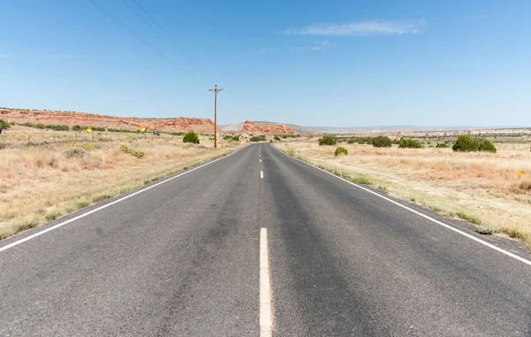 Lange gerade Straße durch die Wüste von New Mexico, USA. — Stockfoto