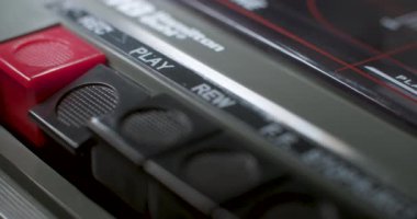 Play Button 'a bas. Eski bir ses kasetçaları üzerinde oynatma tuşuna basılan bir makro yakın plan.