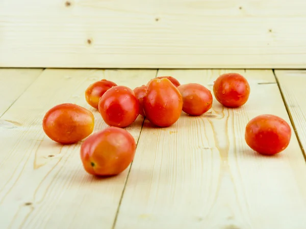 Tomates cherry en mesa de madera; foco central — Foto de Stock
