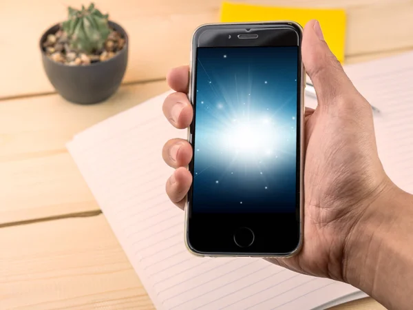 Negro y azul que brilla en la pantalla del teléfono inteligente encendido y sosteniendo — Foto de Stock