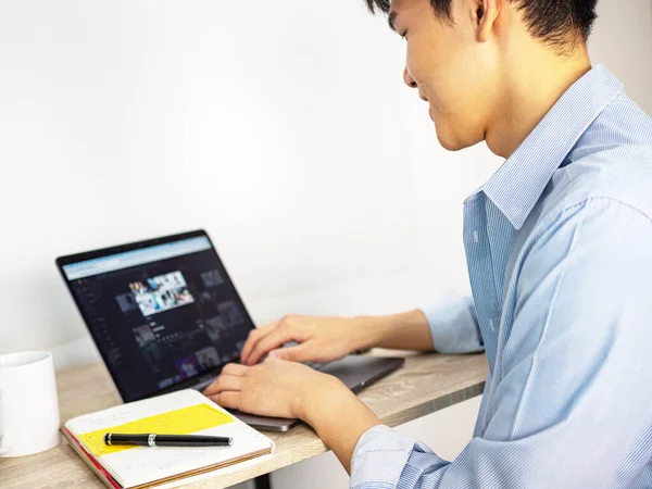 Happy man working on a desk with computer laptop