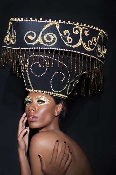 Fashionable woman in a big black golden hat. — Zdjęcie stockowe