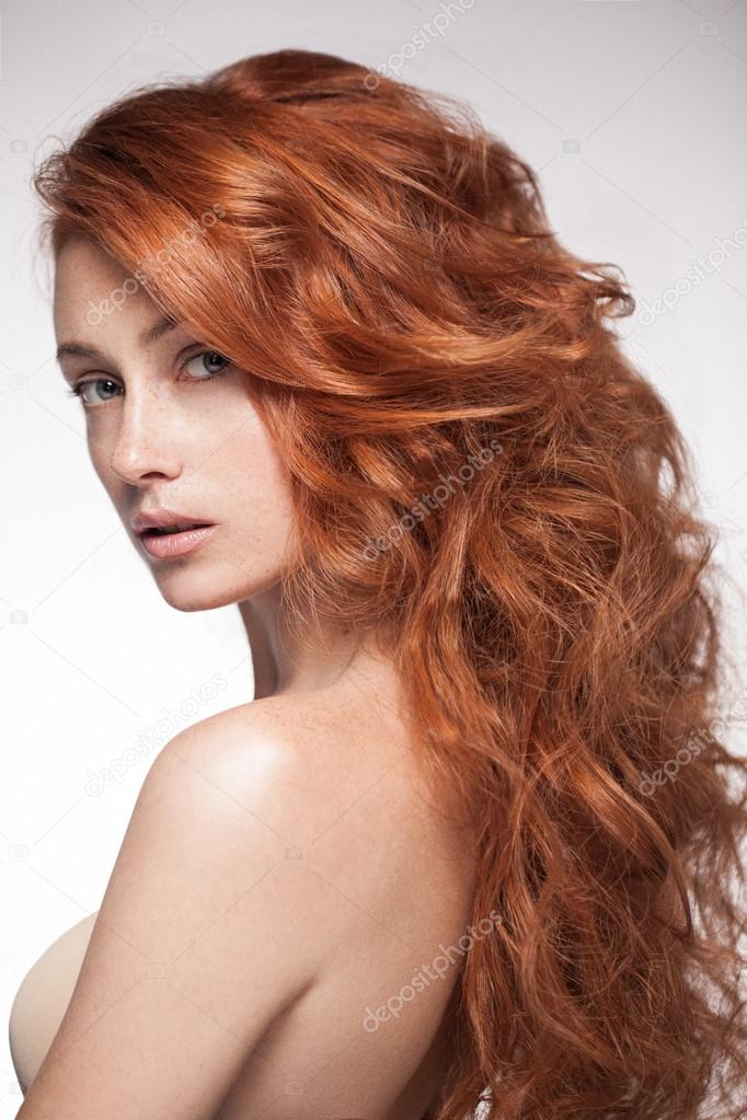 Sensual red head woman posing in studio.