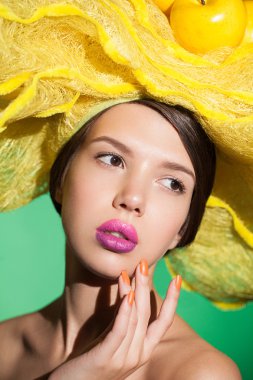 Glamour portrait of a young pretty lady on creative yellow hat.