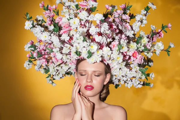 Érzéki lány pózol stúdió lenézett. Fiatal modell csokor virággal a fején. — Stock Fotó