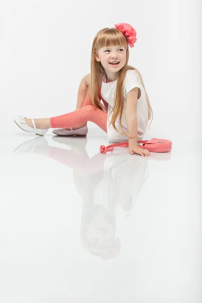 Pouco bonito linda menina bonita sorrindo posando em estúdio sentado no chão . — Fotografia de Stock