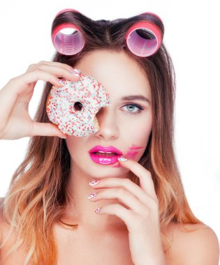 Güzel çekici beyaz kızı tatlı bir pasta alarak saç pembe curlers.