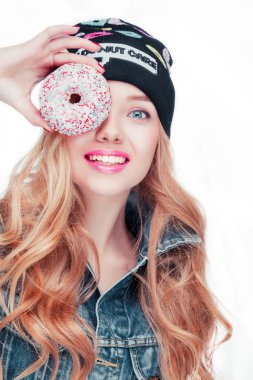 Uzun sarı saçlı, siyah şapka ve denim ceket, çıplak günlük makyaj güzel çekici çekici kız bir tatlı pasta elinde alarak..