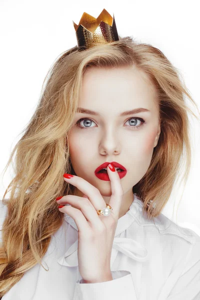 Çıplak makyaj kırmızı dudaklar, kafasına bir küçük altın taç giyen parlak sarı saçlı güzel oldukça beyaz model.