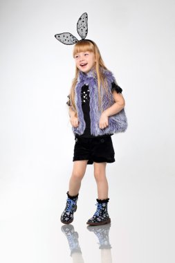 Beautiful little redhead girl sitting on floor in the studio.