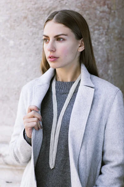 Ceket ve gri süveterli kadın.