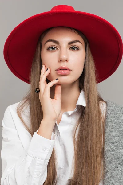 Junges Mädchen mit rotem Hut posiert — Stockfoto