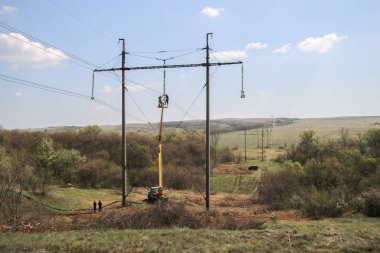 Bir vinç kullanarak yüksek voltajlı elektrik hattını onar