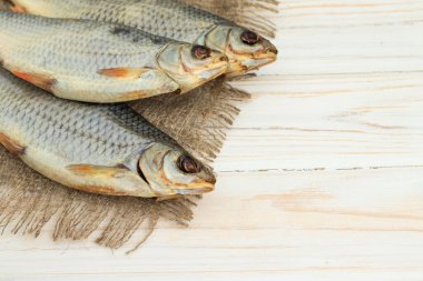 Beyaz ahşap zemin üzerinde kuru balık ve metin için yer var.