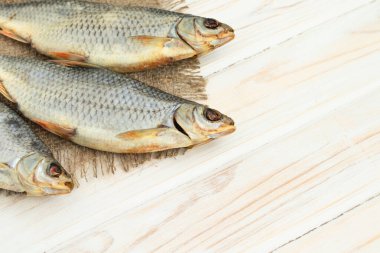 Beyaz ahşap zemin üzerinde kuru balık ve metin için yer var.