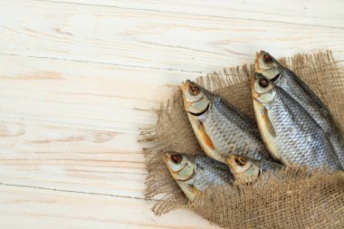 Beyaz ahşap zemin üzerinde kuru balık ve metin için yer var.