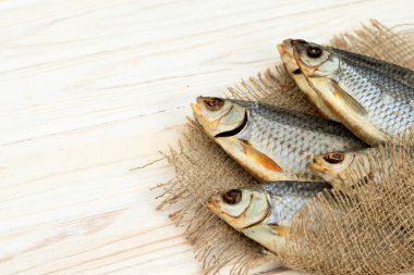 Beyaz ahşap zemin üzerinde kuru balık ve metin için yer var.