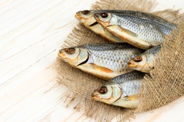 Kuru bir hamamböceği balığı yukarıdan ahşap bir masa manzarasında yatar..