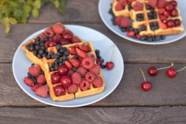 Ulusal Waffle Günü. Ahşap bir arka planda böğürtlenli waffle.