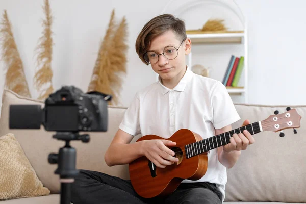 boy tunes guitar, before playing guitar, home teaching music