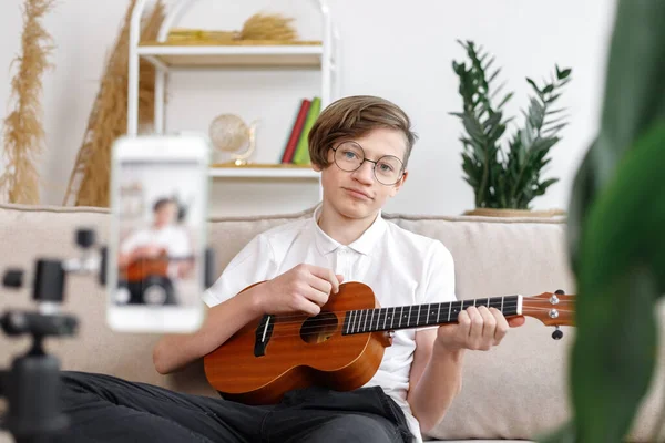 boy tunes guitar, before playing guitar, home teaching music