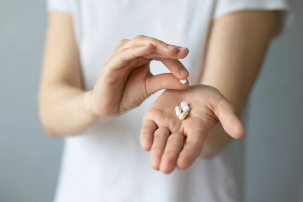 Una mano de las mujeres con pastillas en la palma abierta —  Fotos de Stock