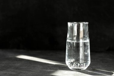 Güneş ışığındaki siyah bir zemin üzerindeki şeffaf cam güzel ışınlar ve parlaklıklar verir.