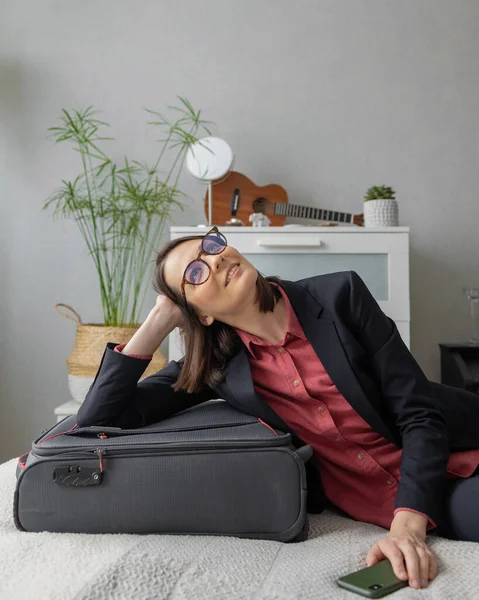 Feliz europeo Millennial mujer de negocios está empacando para el camino, haciendo su maleta para un viaje de negocios o de estudio — Foto de Stock